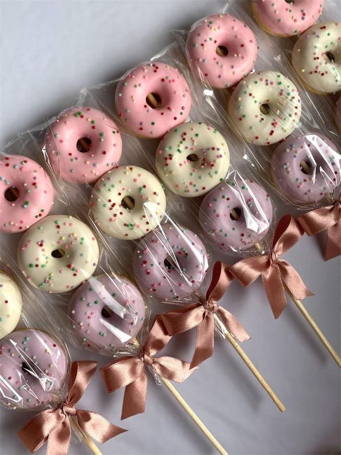 Mini donuts coloridos no palito embalados com laço