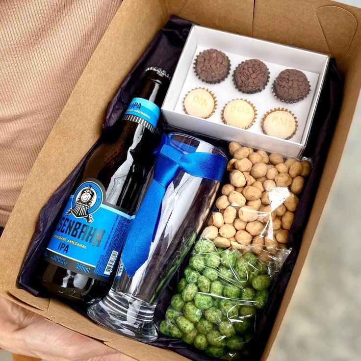 Caixa com cerveja, copo, petiscos e docinhos