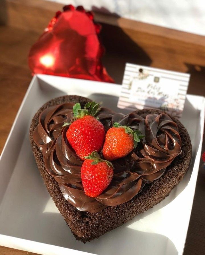Bolo de coração com cobertura de chocolate e morangos